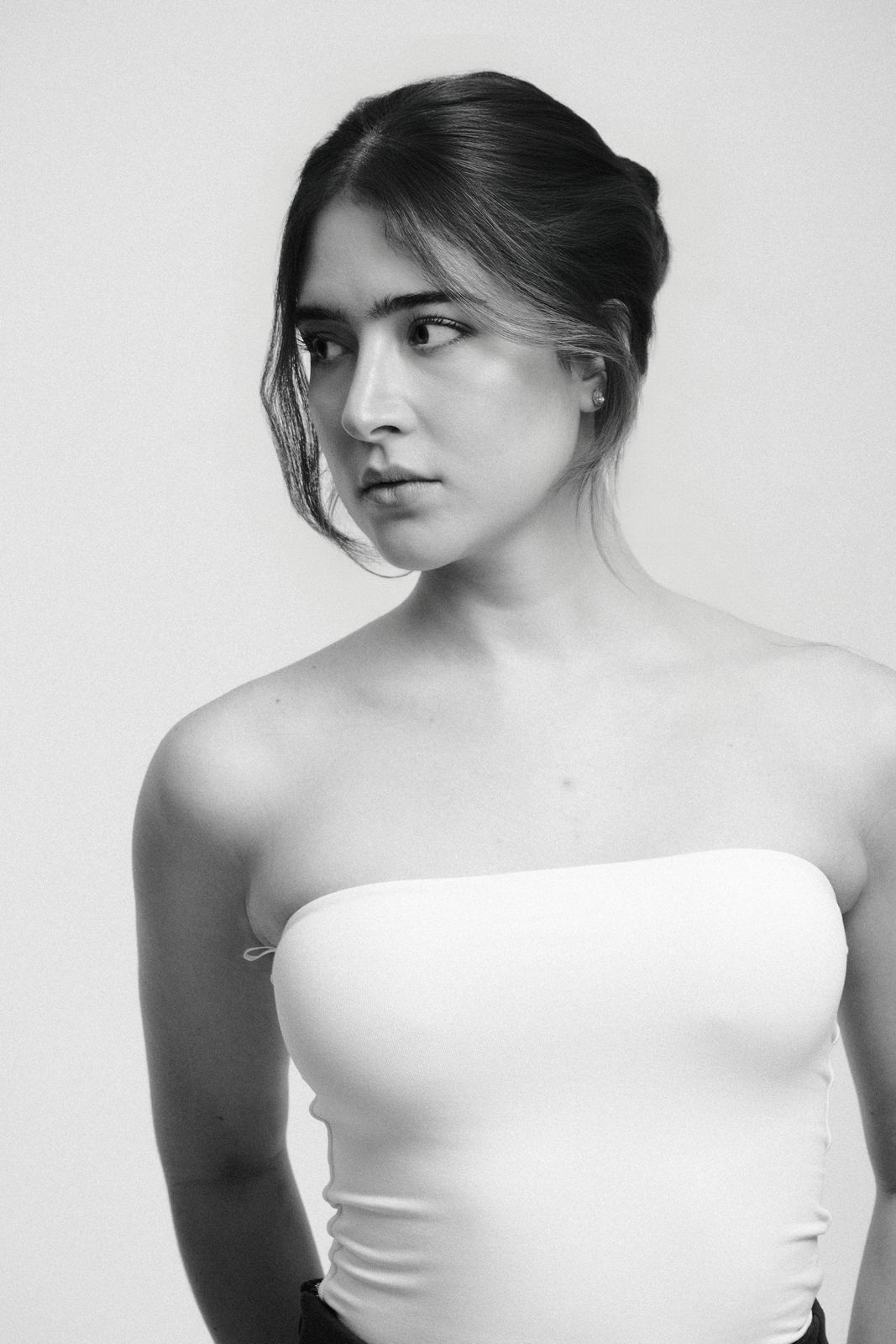 Paola Beatriz Miralles, black and white headshot, hair up, looking away to the left