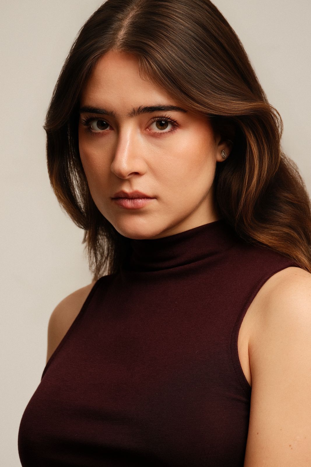 Paola Beatriz Miralles, colour headshot, looking straight into the camera, wearing a dark burgundy sleeveless top